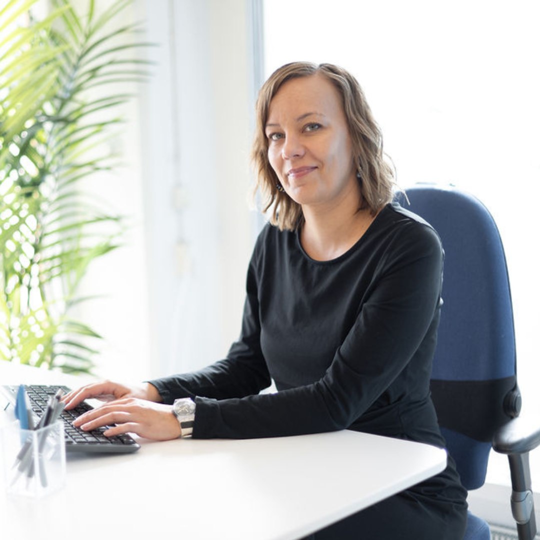 nainen istuu työpöydän ääressä