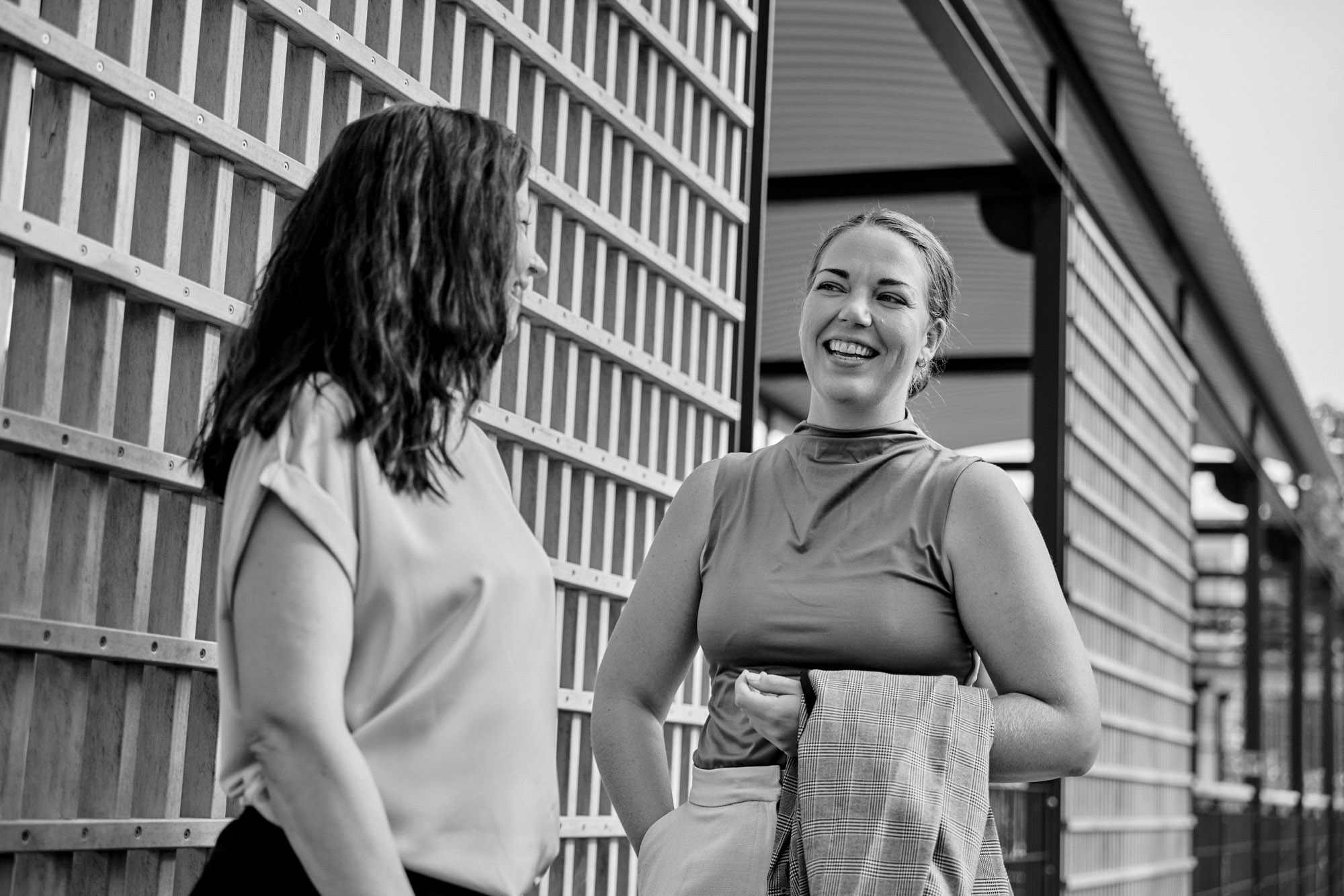 Kaksi Bondatan asiantuntijaa keskustelee iloisesti toimistorakennuksen ulkopuolella