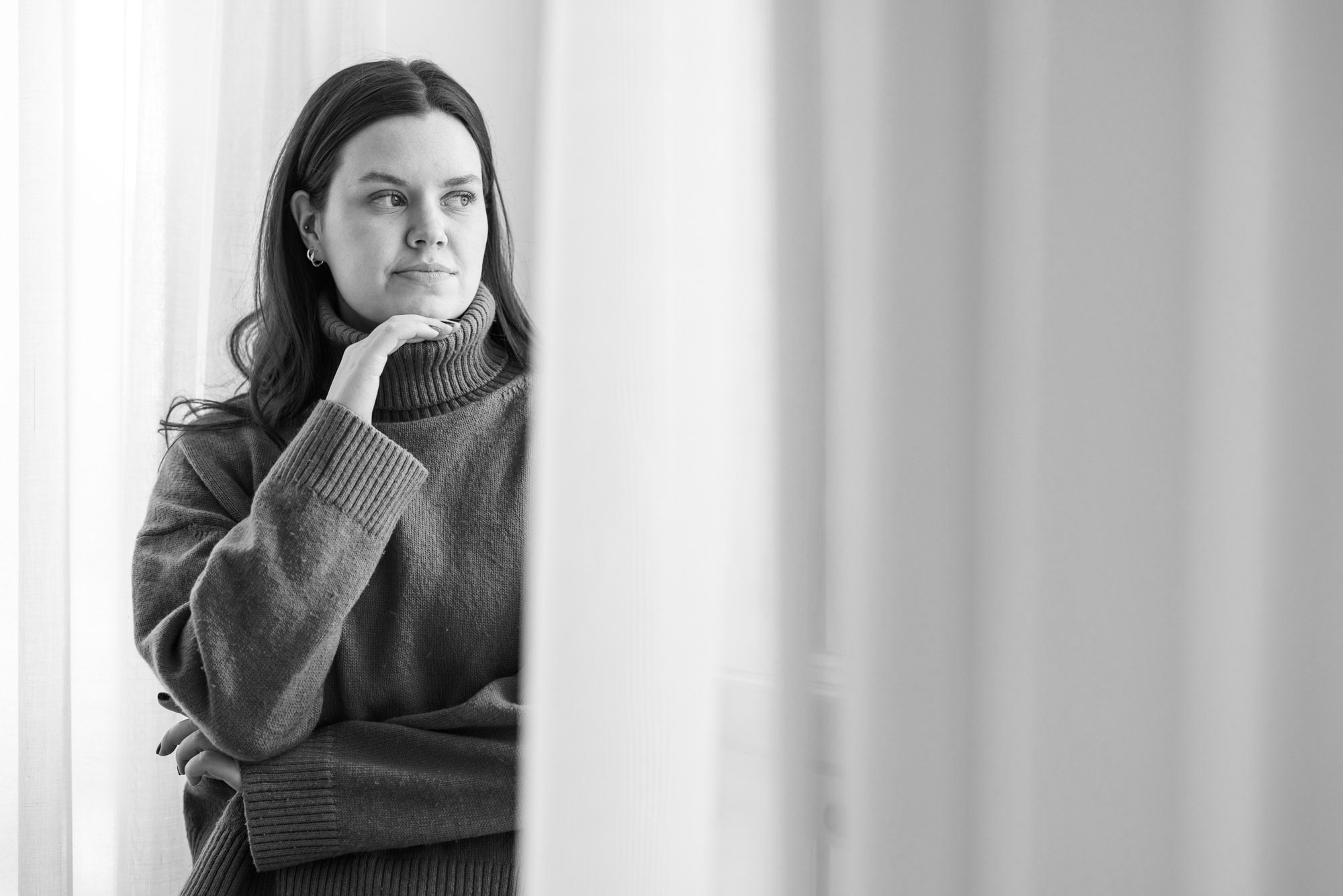 Nuori nainen katselee ikkunalla mietteliäänä ulos ja pohtii tulevaisuuttaan.